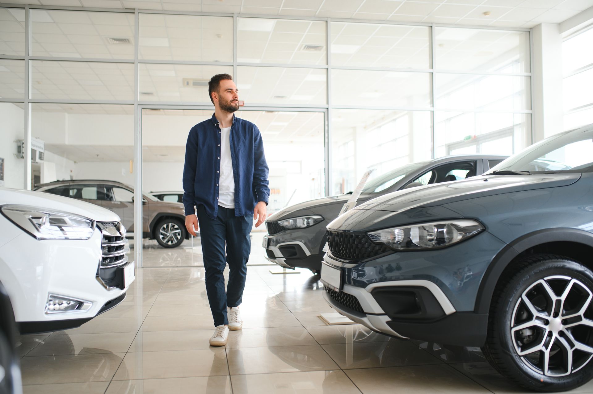 Homme déambulant parmi des véhicules neufs