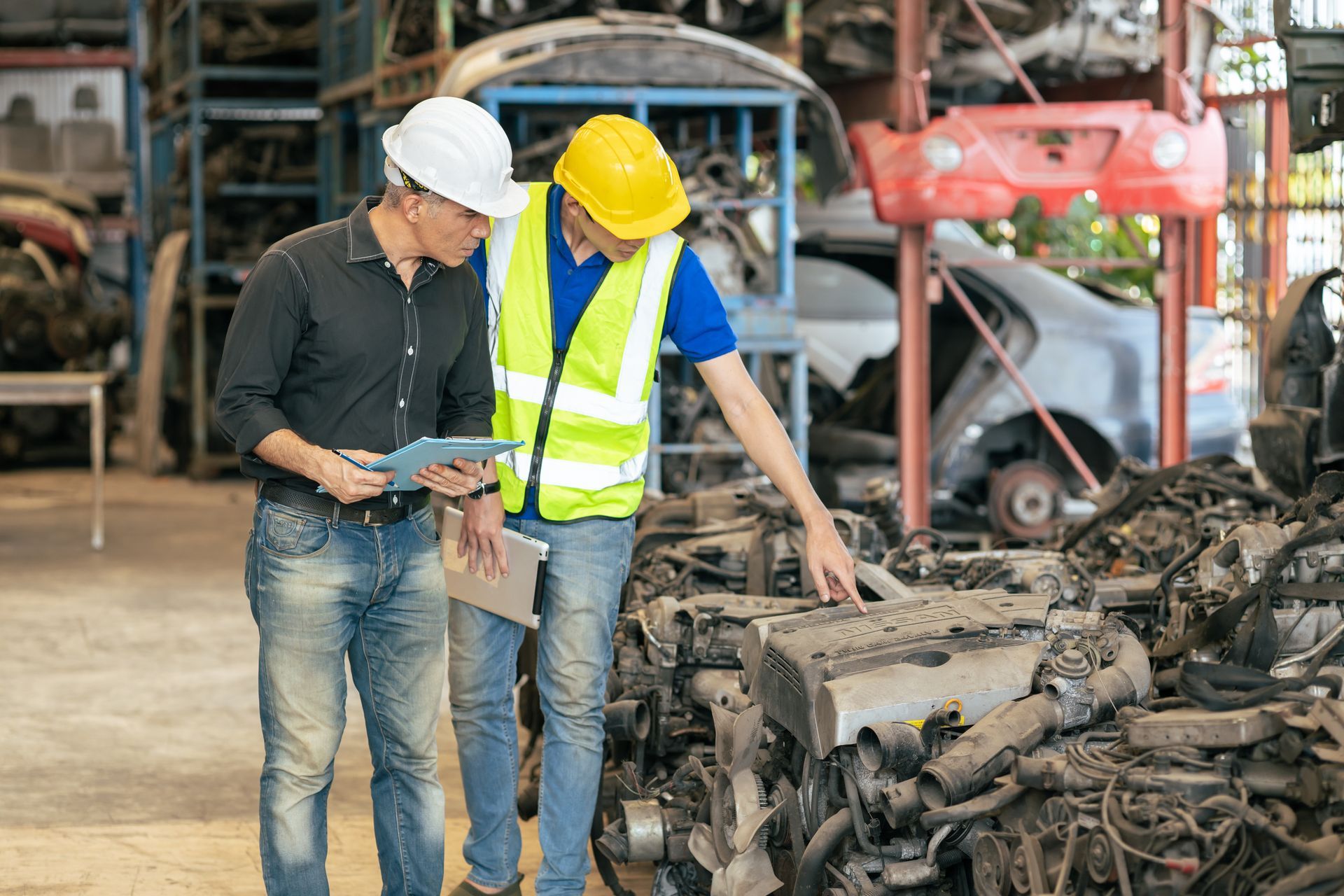 Deux hommes à côté d'un stock de pièces détachées