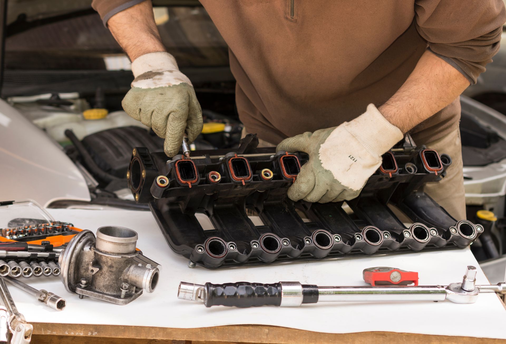 Homme en train de démonter une partie d'un moteur
