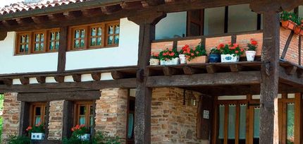 Una casa con balcón y flores.