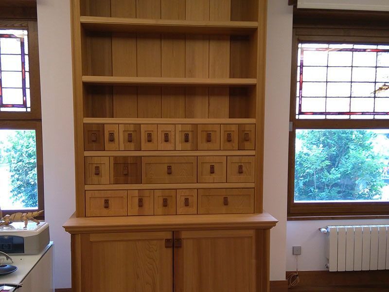 Un armario de madera con cajones y estantes en una habitación.