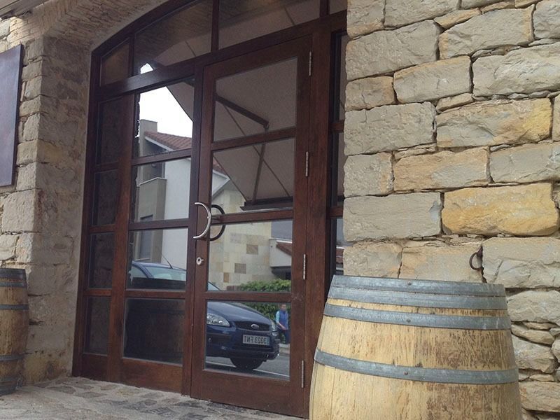 Una puerta de madera con un barril delante de ella.