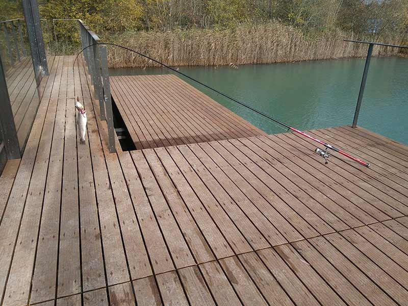 Una terraza de madera con vista a un cuerpo de agua.