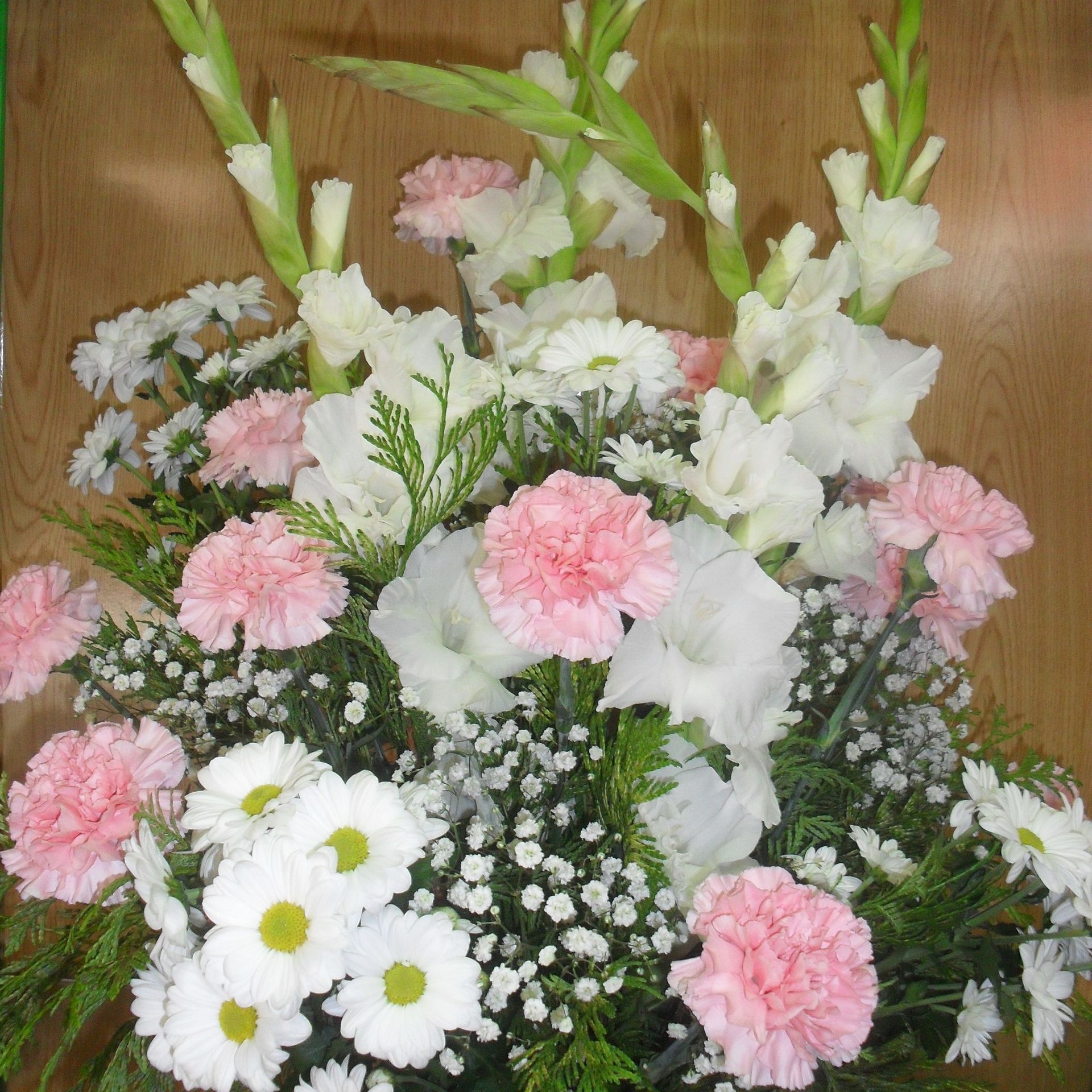 Un ramo de flores rosas y blancas sobre una mesa de madera.