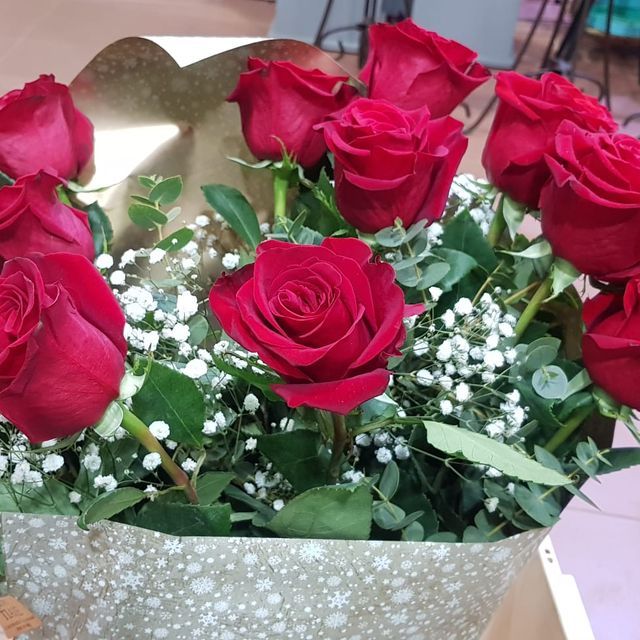 Un ramo de rosas rojas con aliento de bebé