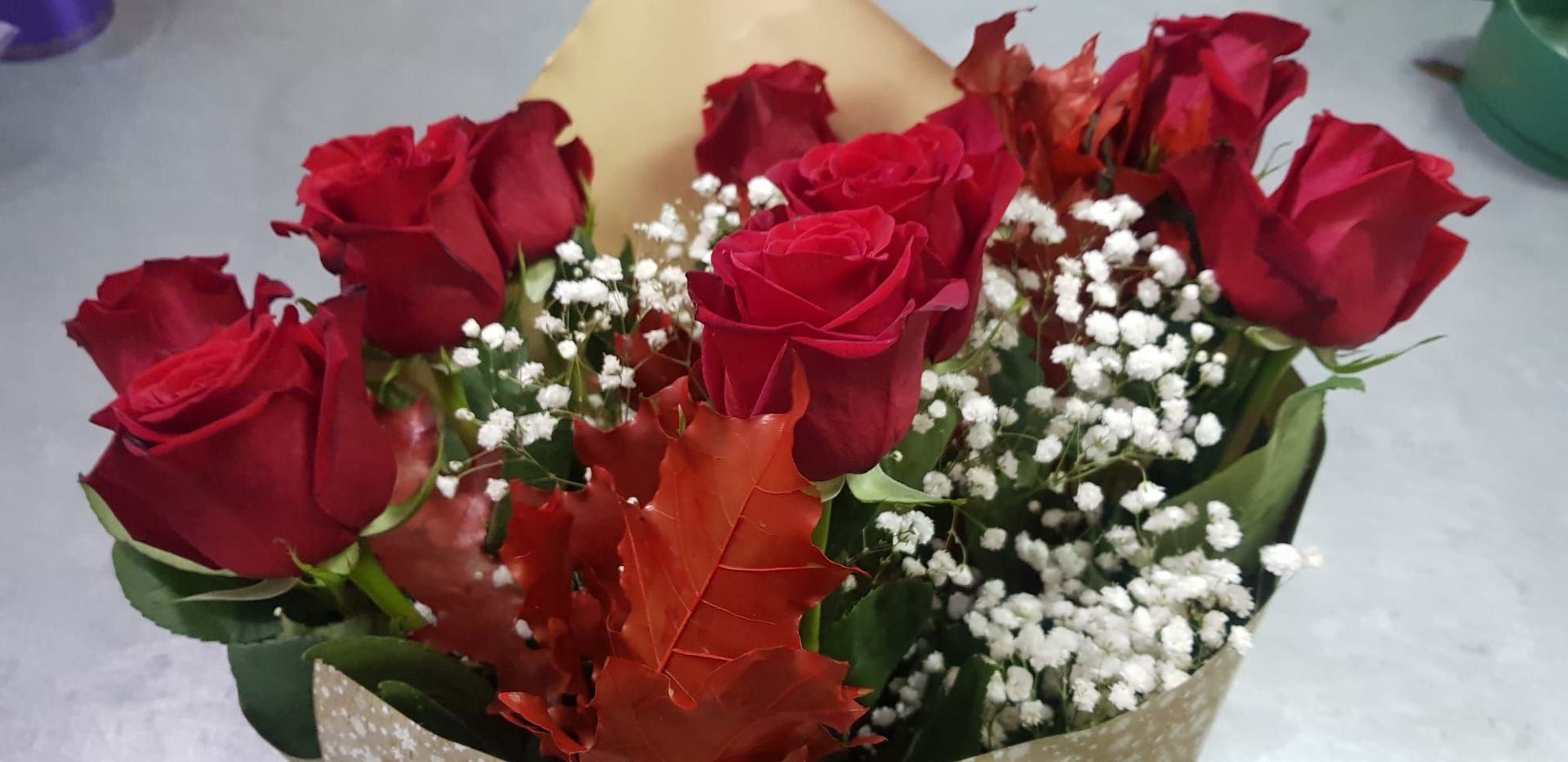 Un primer plano de un ramo de rosas rojas con aliento de bebé.