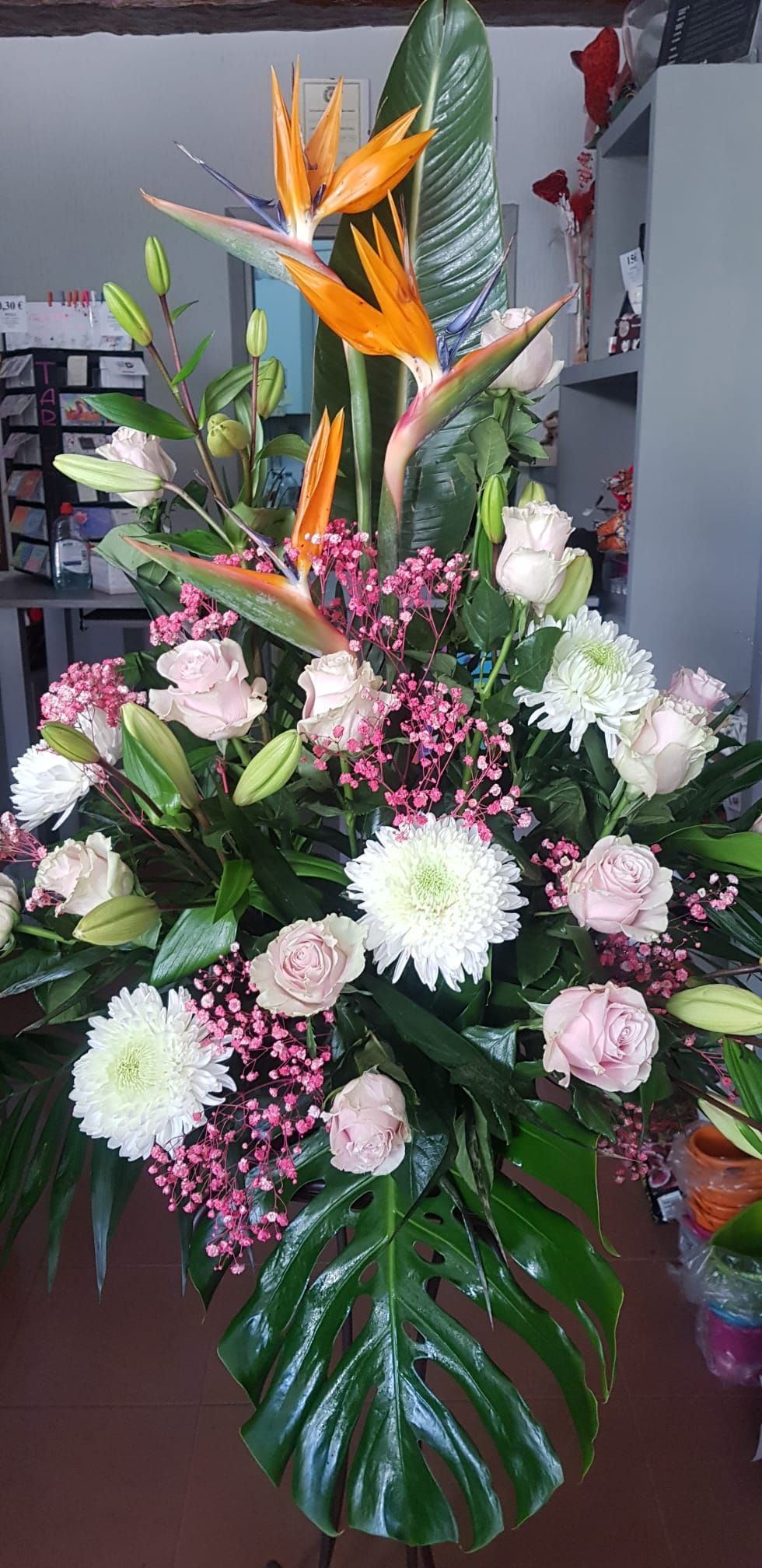 Un gran ramo de flores está sobre una mesa en una habitación.
