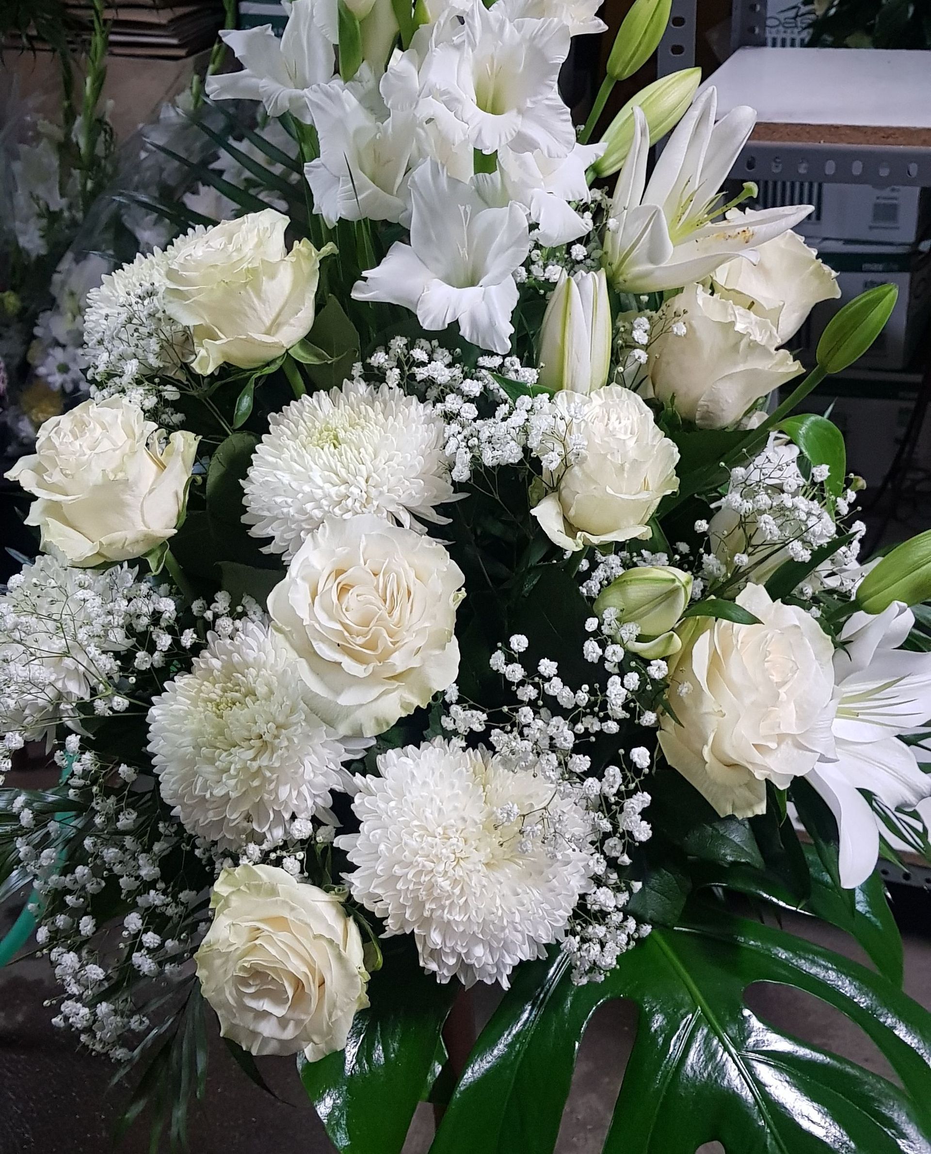 Un gran ramo de flores blancas está sobre una mesa.