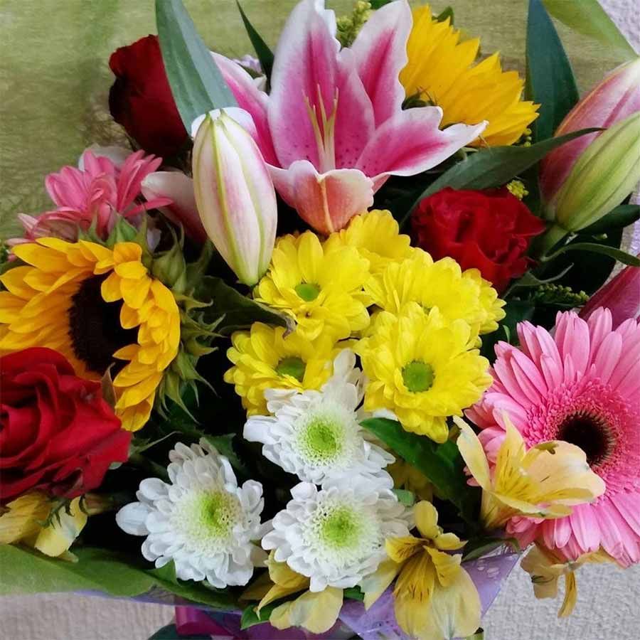 Un ramo de flores que incluye girasoles y margaritas.