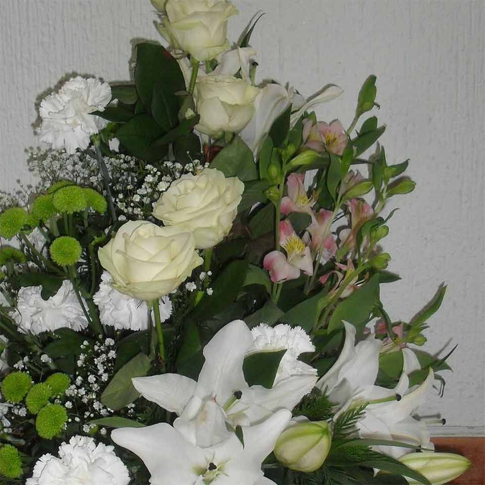 Un ramo de flores blancas con hojas verdes