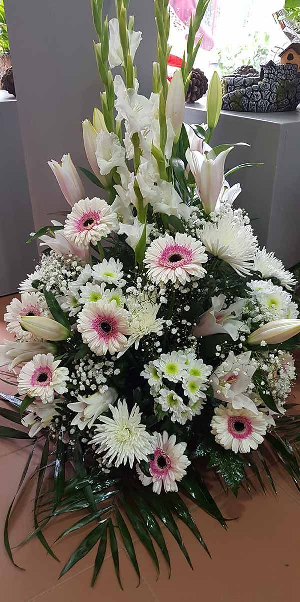 Un gran ramo de flores blancas y rosas está sobre una mesa.