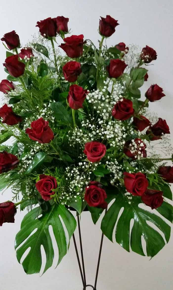 Un jarrón lleno de rosas rojas y aliento de bebé.