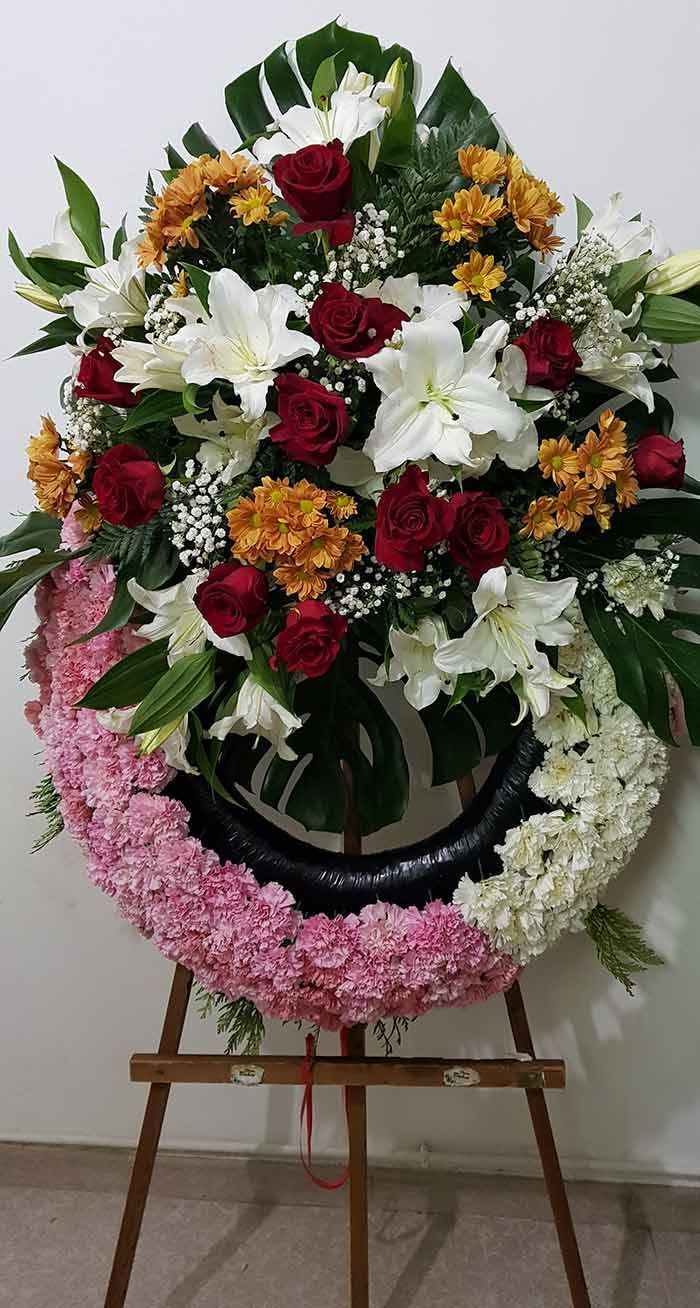 Una corona de flores reposa sobre un caballete de madera.