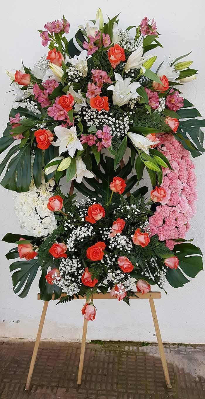 Una corona de flores reposa sobre un caballete de madera.