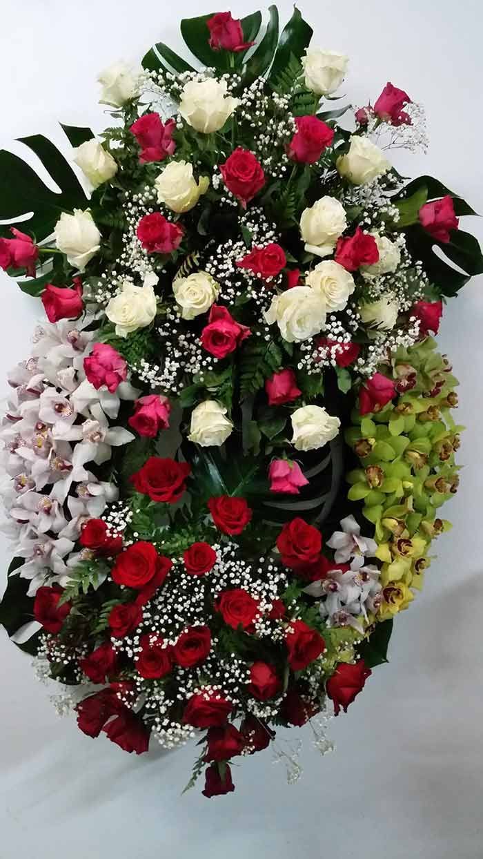 Una corona de rosas rojas y blancas y orquídeas