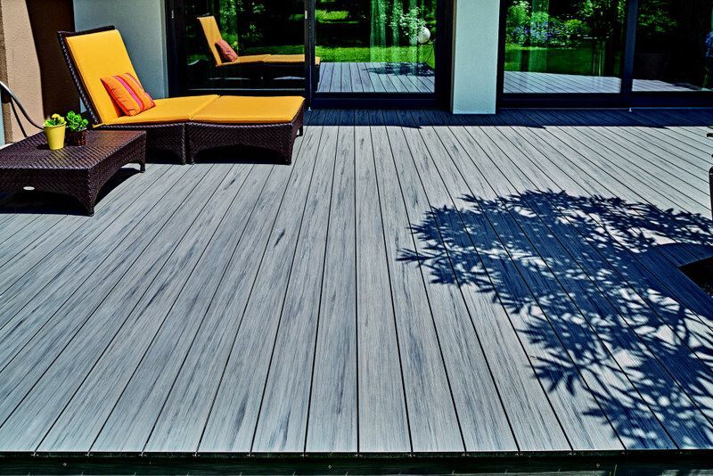 Une terrasse en bois avec des chaises et une table dessus