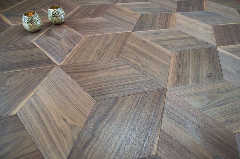 Un parquet avec un motif géométrique et deux bougies dessus.
