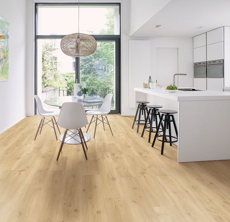 Une cuisine avec une table et des chaises et une grande fenêtre.