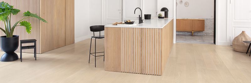 Une cuisine avec un îlot en bois et un comptoir blanc.