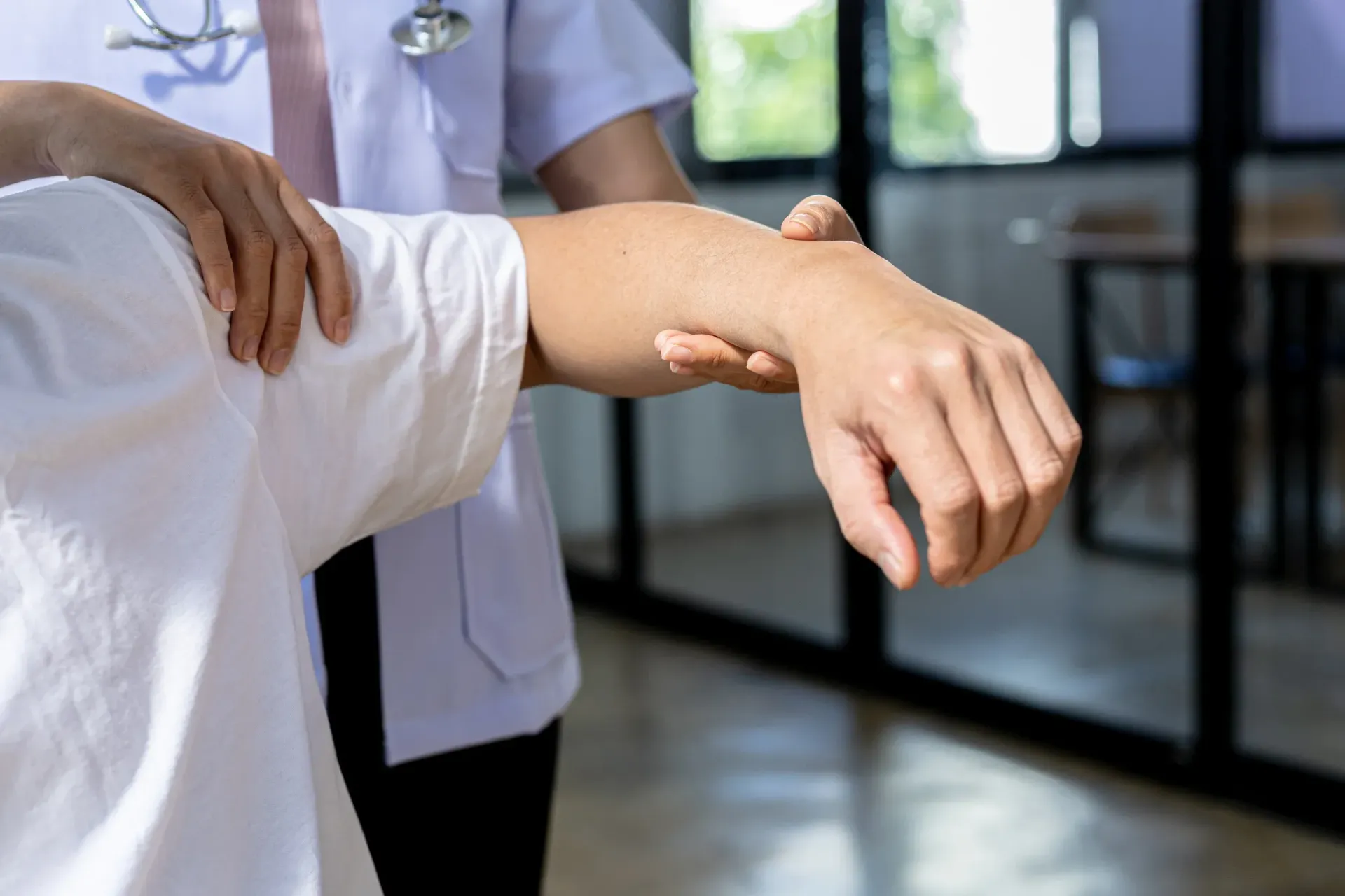 Médico examina el brazo de un paciente para comprobar si hay lesiones o dolor.