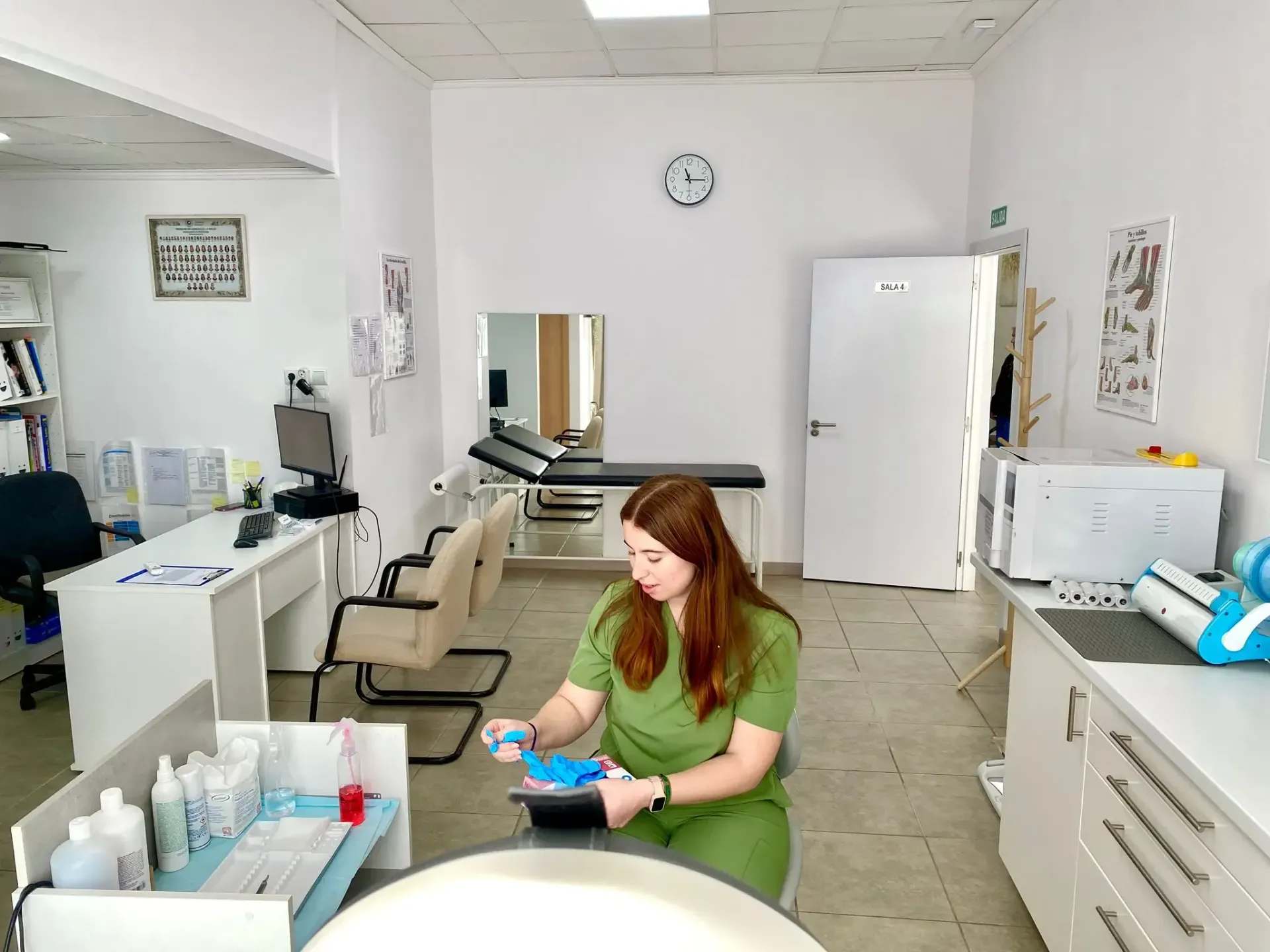 Manos con guantes recortando las uñas de los pies con un cortaúñas.