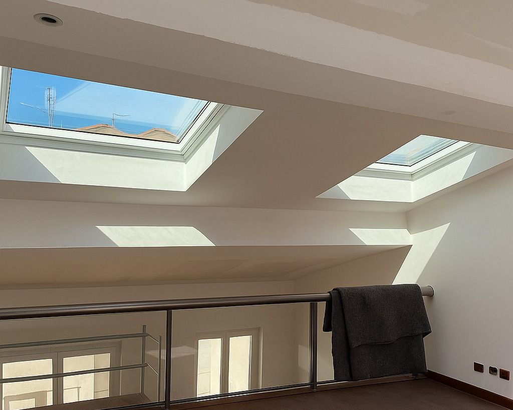 Intérieur avec puits de lumière, rambarde métallique et couverture. La lumière du soleil illumine l'espace.