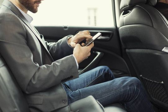 Mann im Taxi arbeitet am Handy