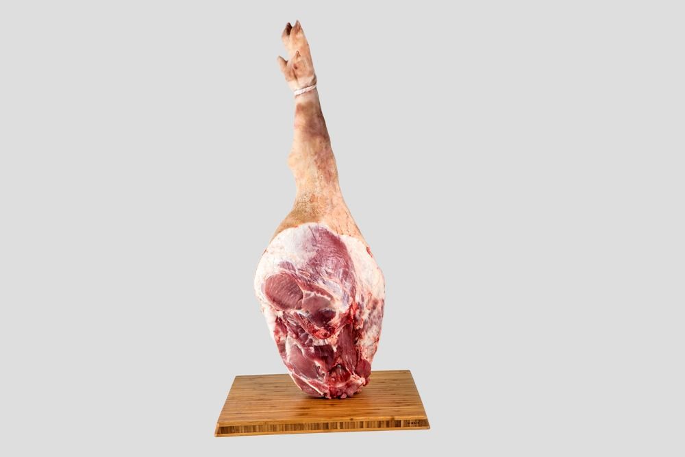 Un trozo de carne está colocado encima de una tabla de cortar de madera.