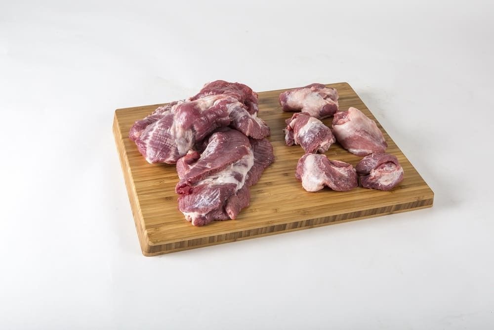 Un montón de carne cruda sobre una tabla de cortar de madera.