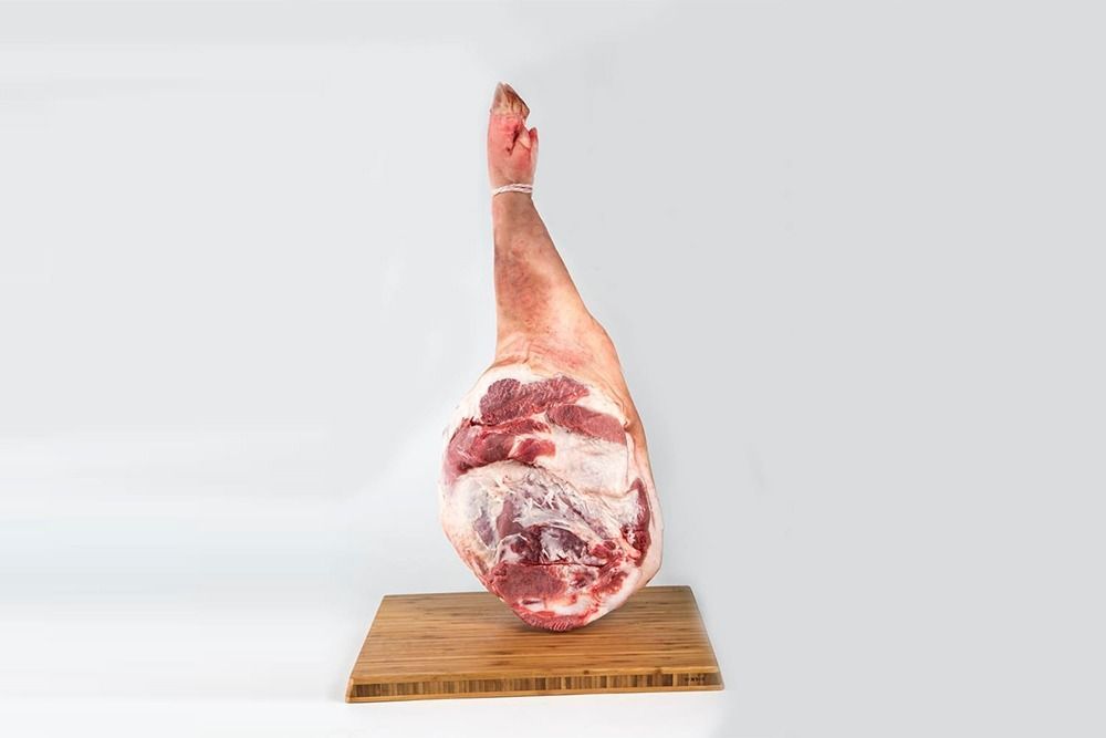 Un trozo de carne está colocado encima de un bloque de madera.