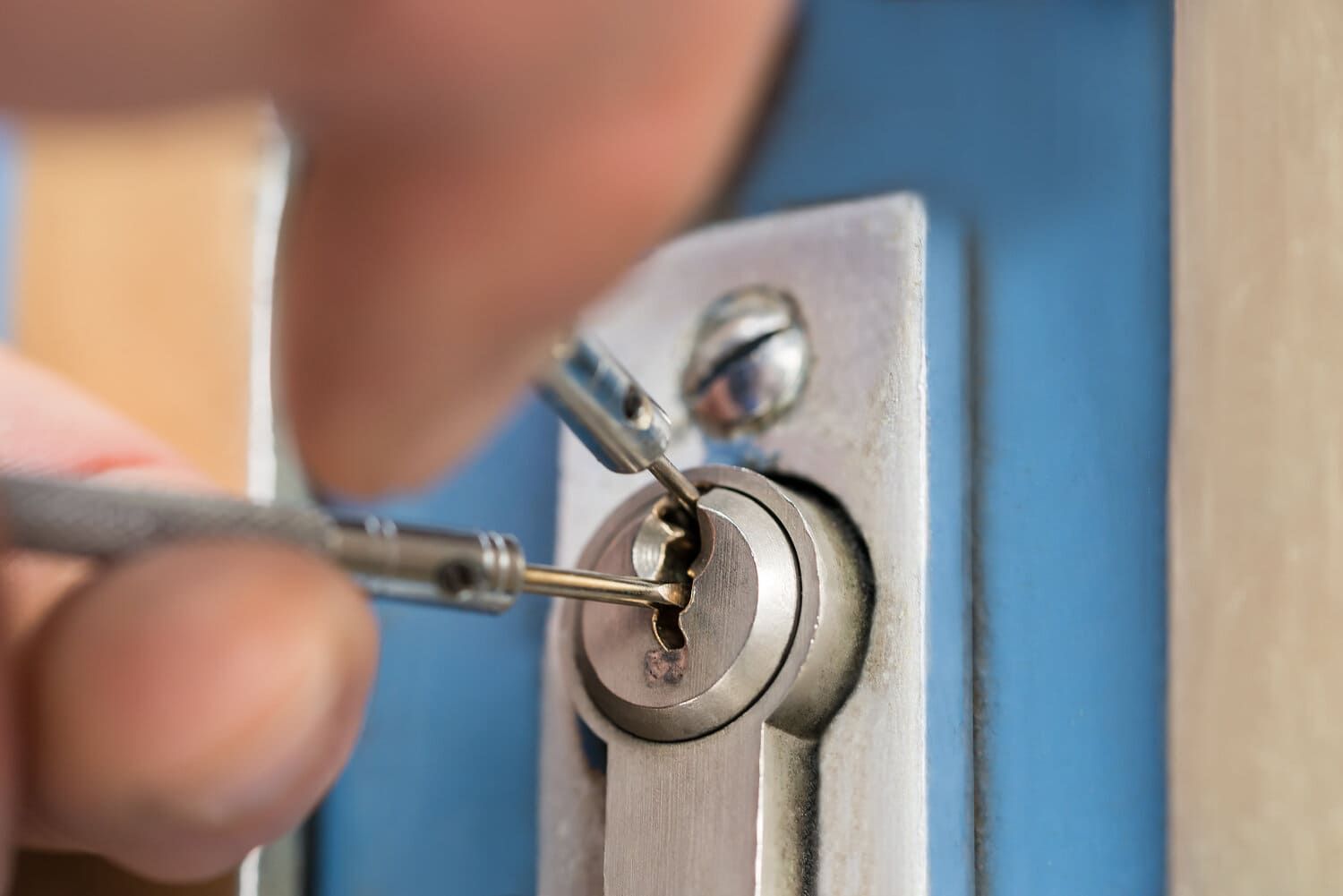 Una persona está usando un destornillador para abrir la cerradura de una puerta.