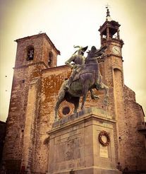 Una estatua de un hombre montado a caballo frente a una iglesia.