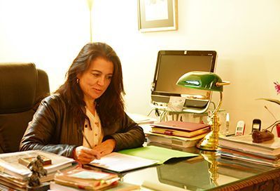 Una mujer está sentada en un escritorio frente a una computadora.