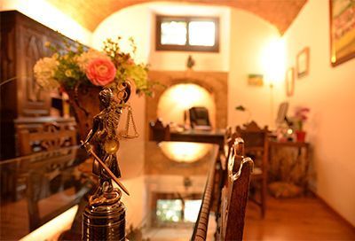 Una estatua de la justicia está sentada en una mesa junto a un jarrón de flores.