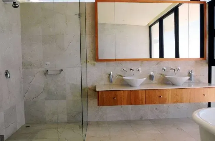 Casa de banho com dois lavatórios e um chuveiro.