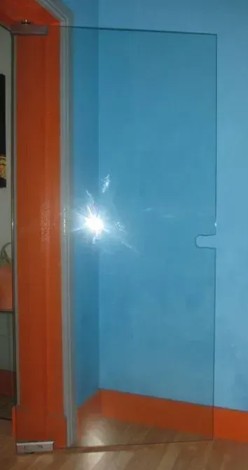 Uma parede azul com acabamento laranja e uma porta de vidro