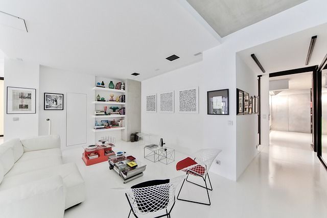 Una sala de estar con un sofá blanco y sillas.