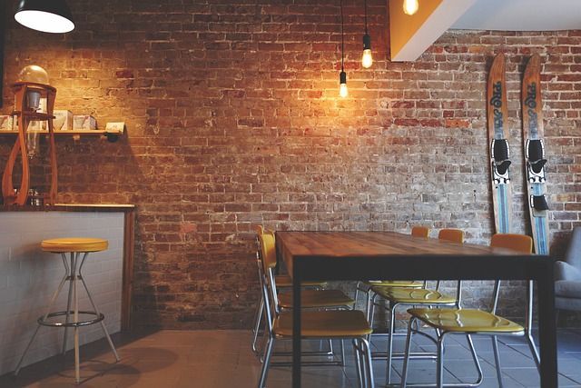 Un comedor con una mesa y sillas y una pared de ladrillos.