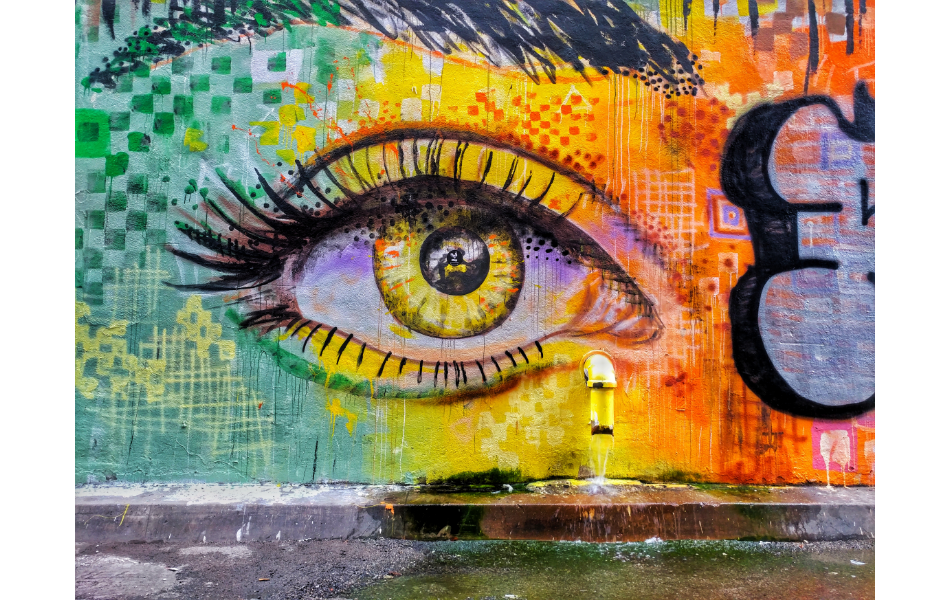 Una colorida pintura de graffiti del ojo de una mujer en una pared.