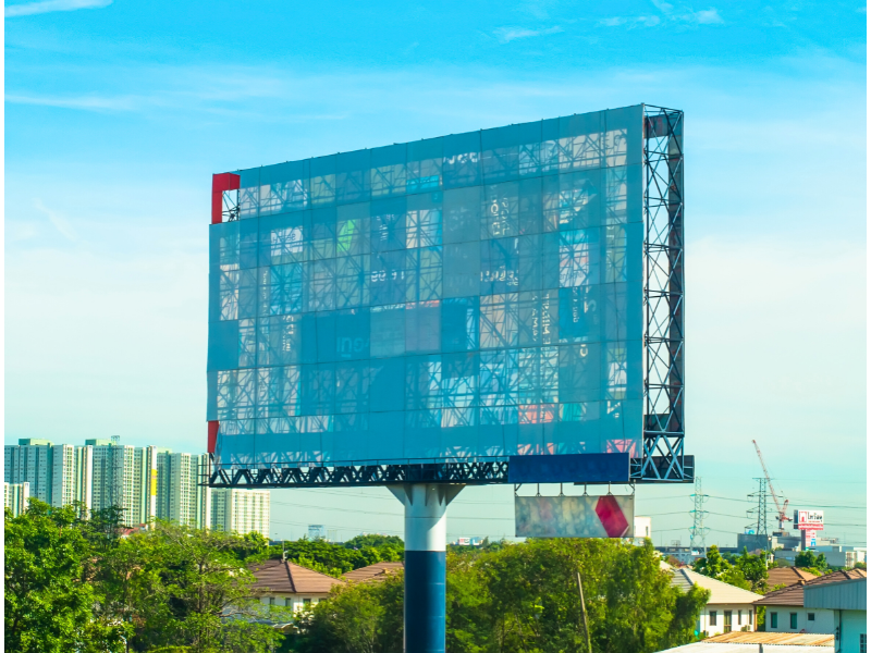 Un gran cartel publicitario está situado en el centro de una ciudad.