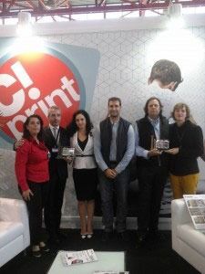 Un grupo de personas posa para una fotografía frente a un cartel que dice imprimir.