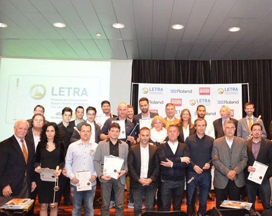 Un grupo de personas de pie frente a un cartel con letras