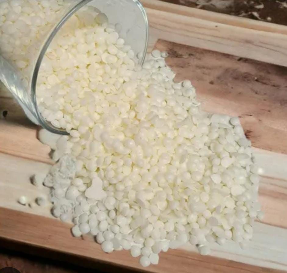 Hay tres velas sobre una mesa al lado de flores.