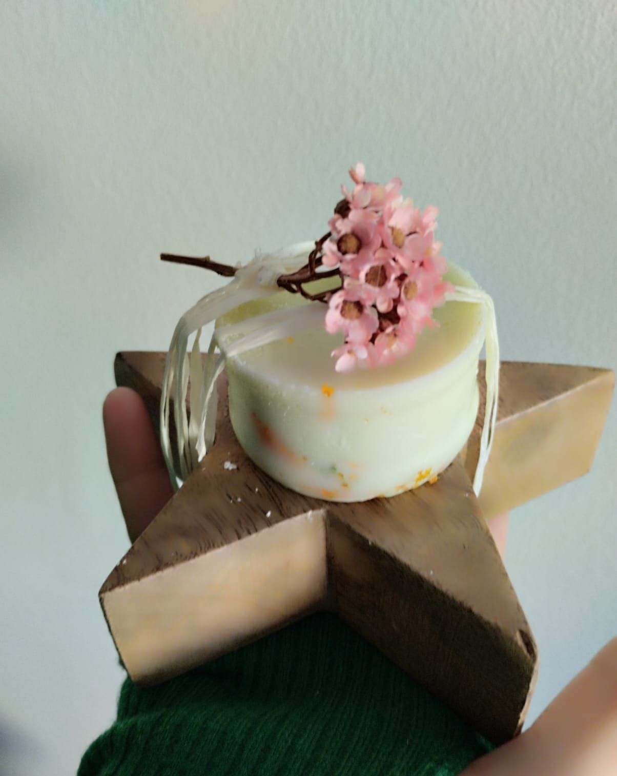 Hay tres velas sobre una mesa al lado de flores.