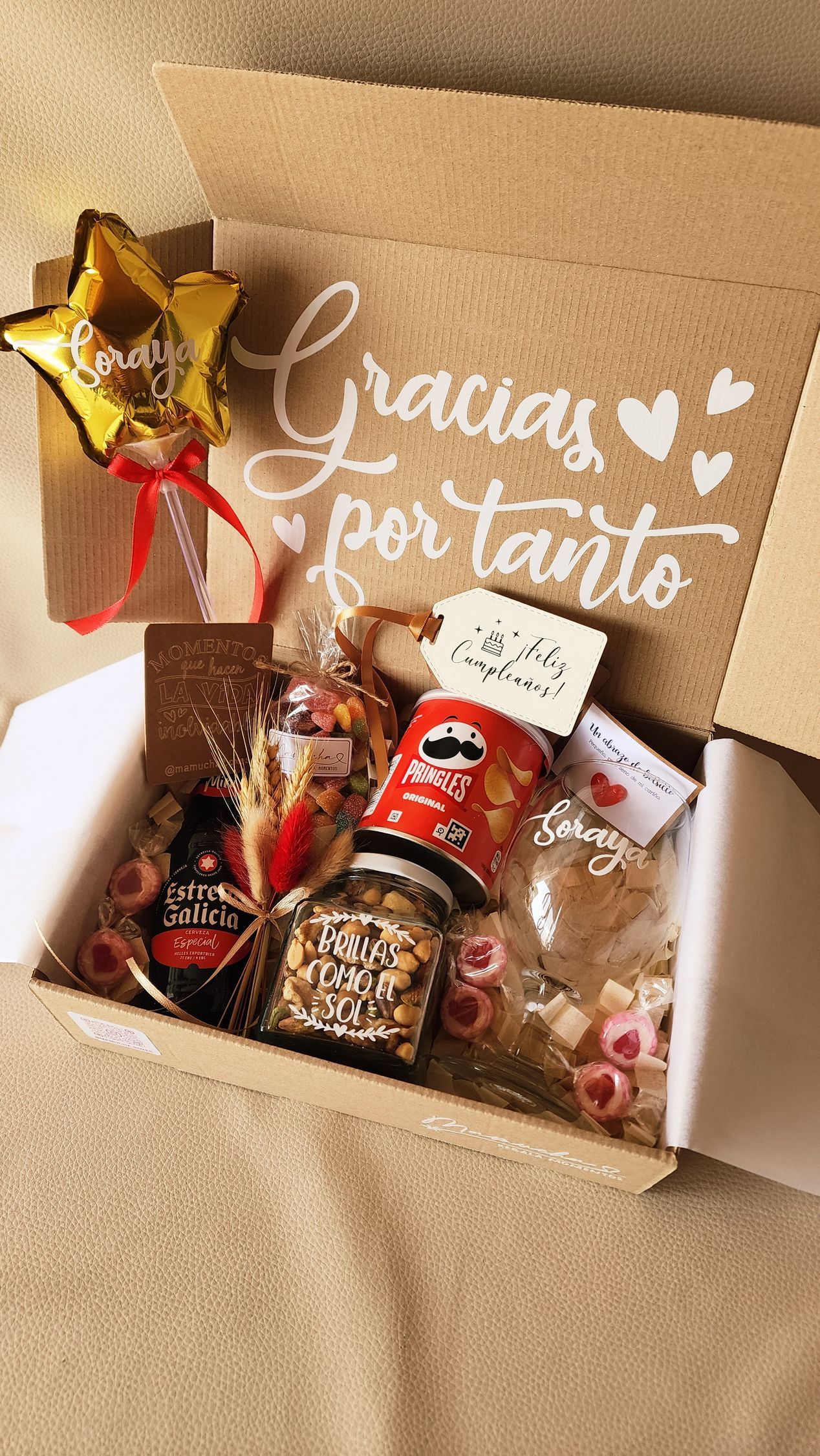 Una caja llena de un cuaderno, un bolígrafo, frascos de nueces y notas adhesivas.