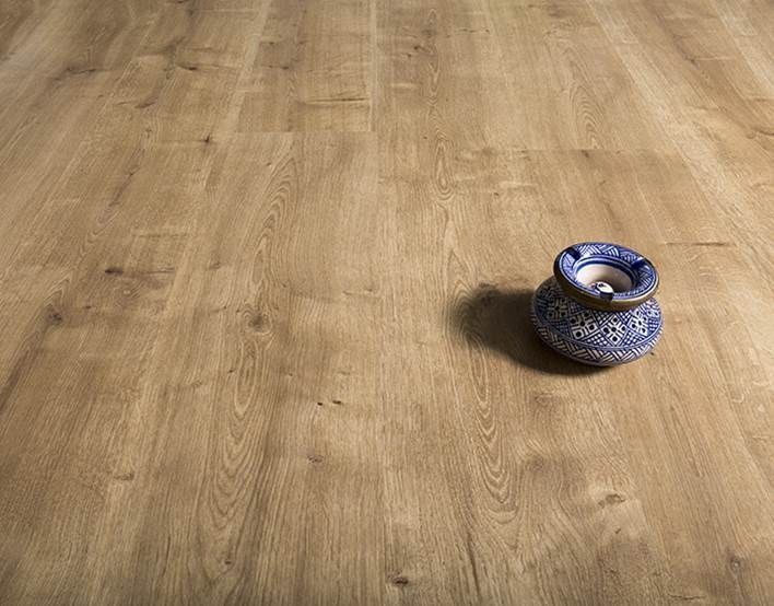 Piso de madera con un candelabro de cerámica azul y blanca que proyecta una sombra.