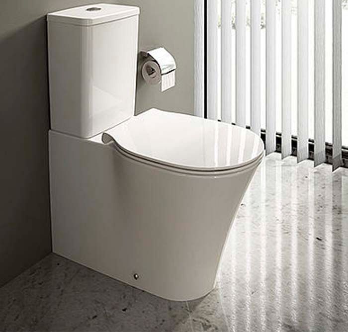 Inodoro blanco moderno con cisterna fijada a la pared, junto a una ventana con persianas verticales. Rollo de papel higiénico en la pared.