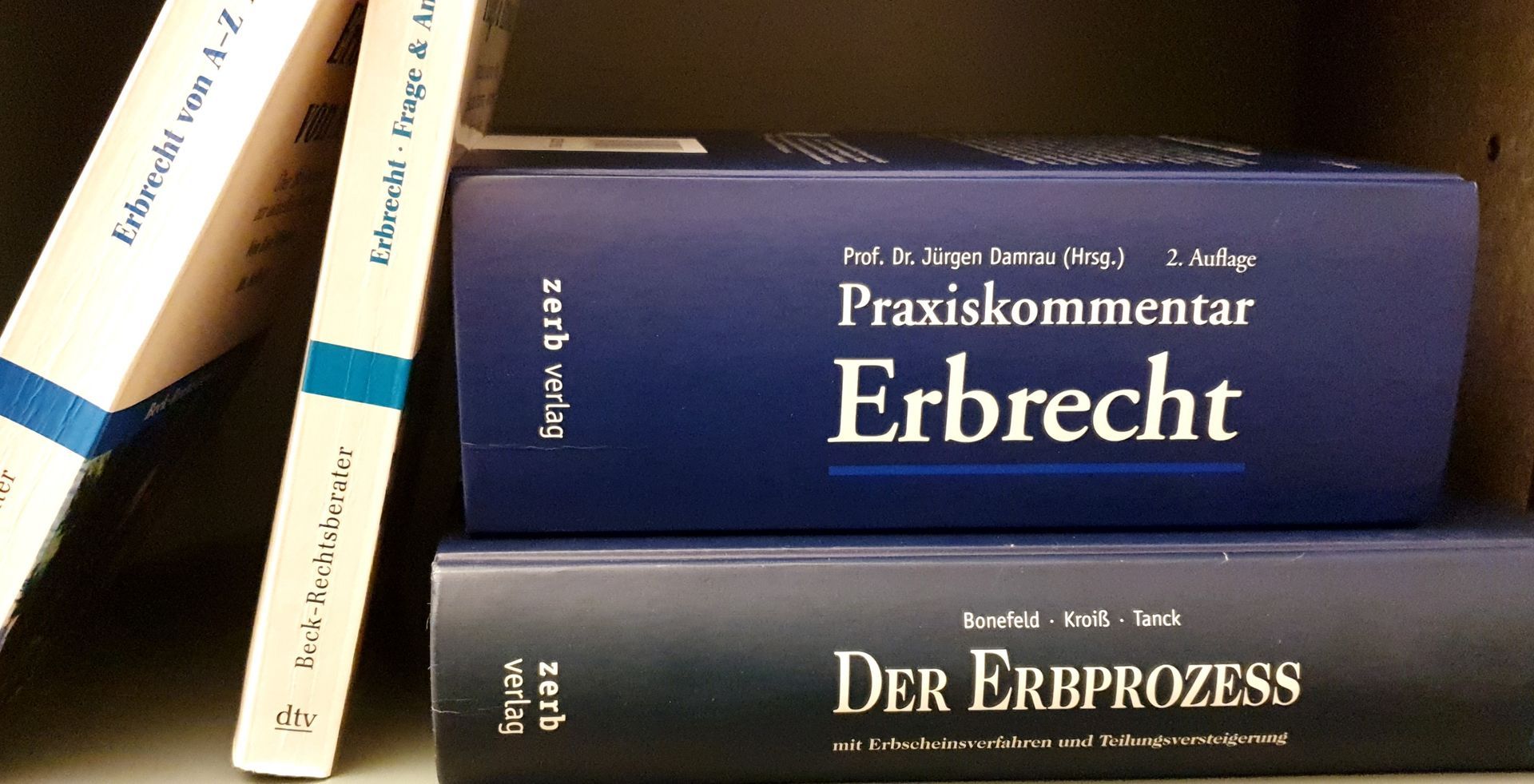 Eine Frau sitzt an einem Schreibtisch, auf dem eine Waage der Gerechtigkeit liegt.