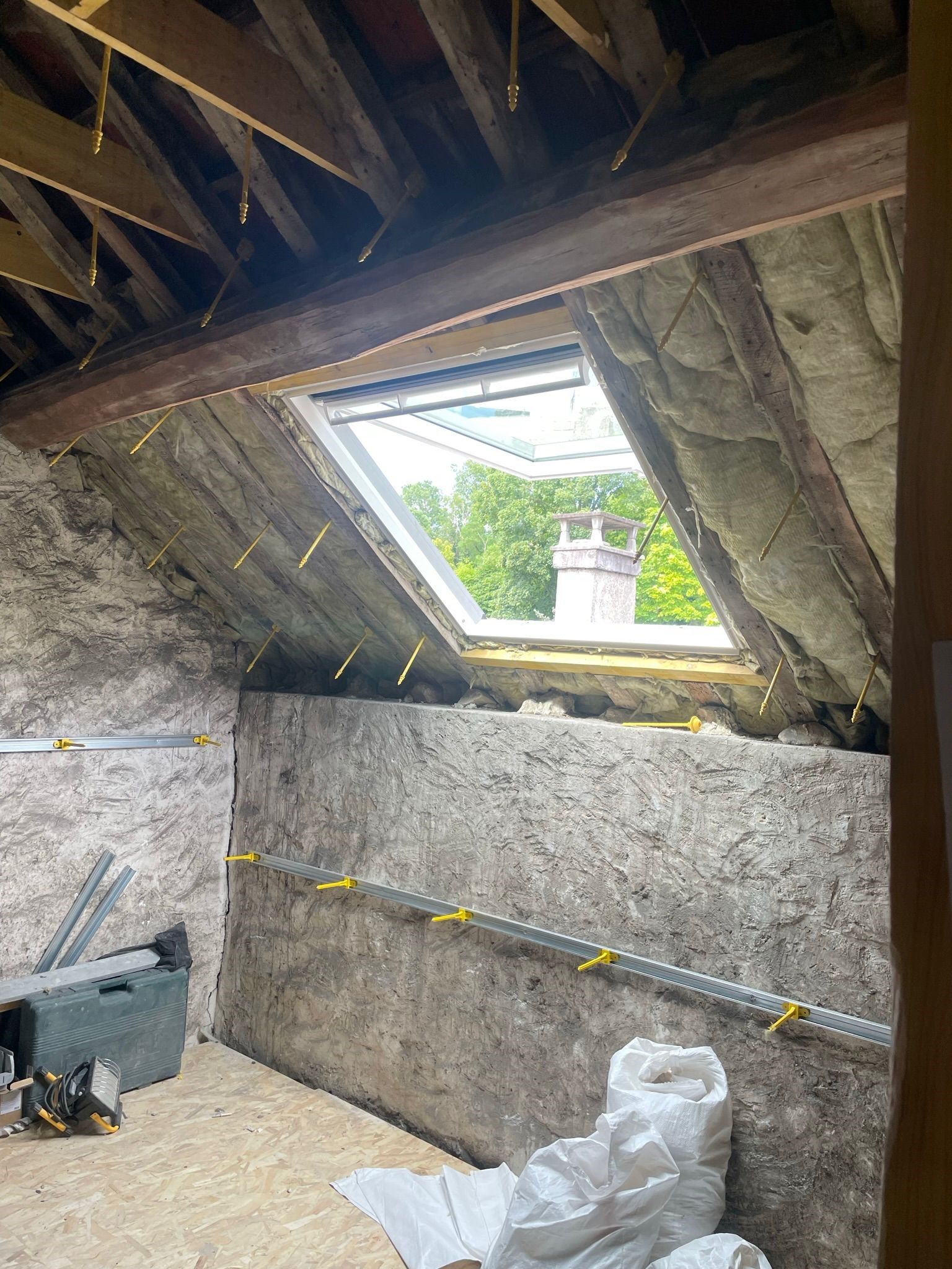 Fenêtre de toit vue de l'intérieur des combles en travaux.