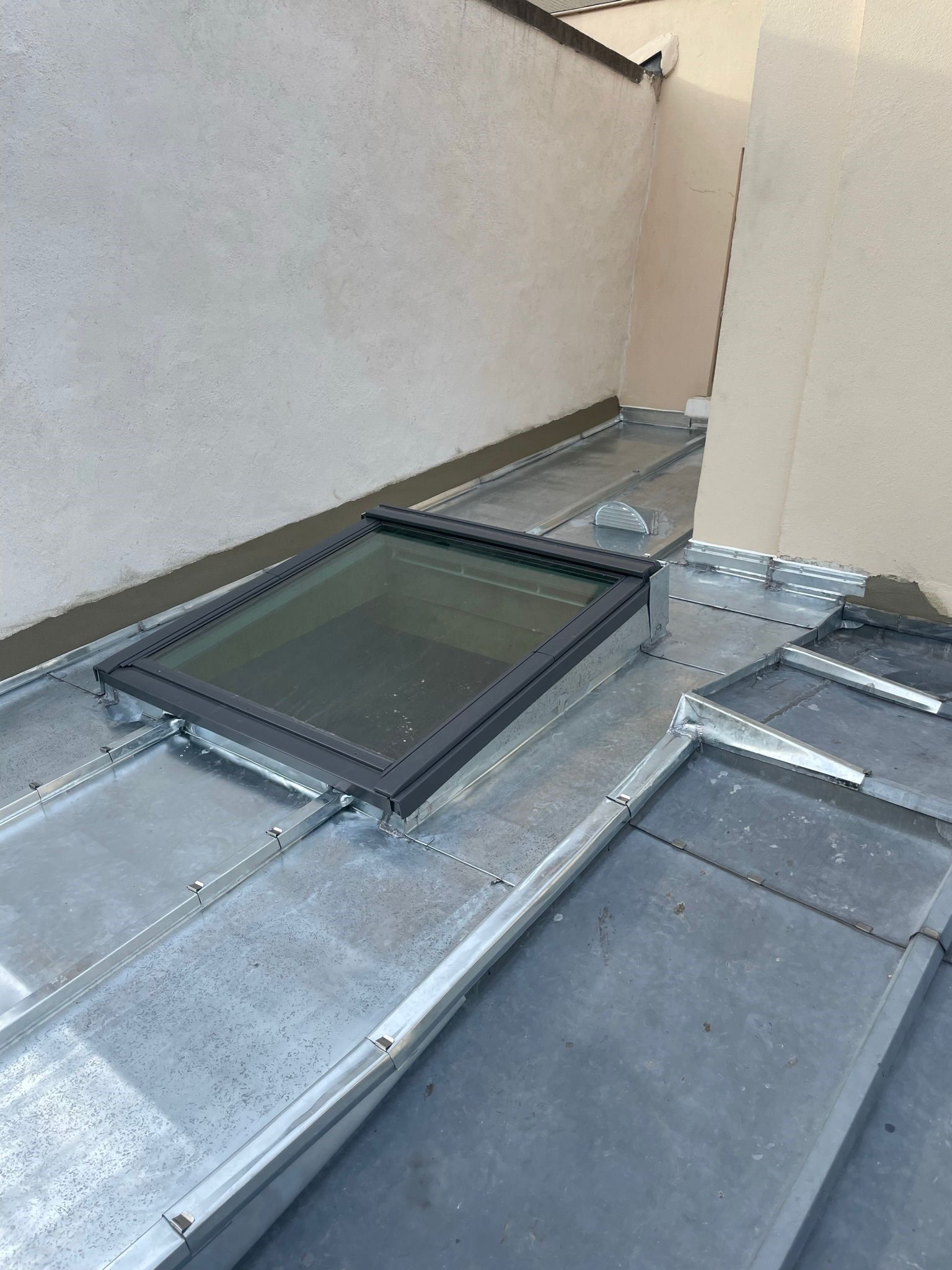 Fenêtre de toit sur toiture plate en zinc.